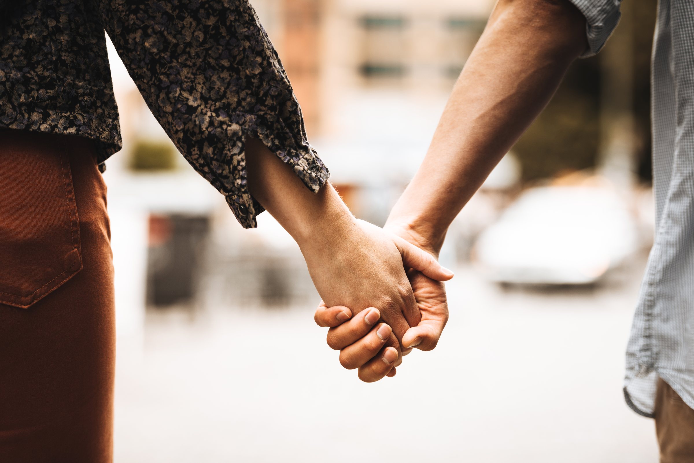 A couple holding hands as they walk together